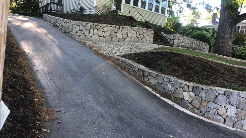 Multi-tier stone retaining walls along driveway